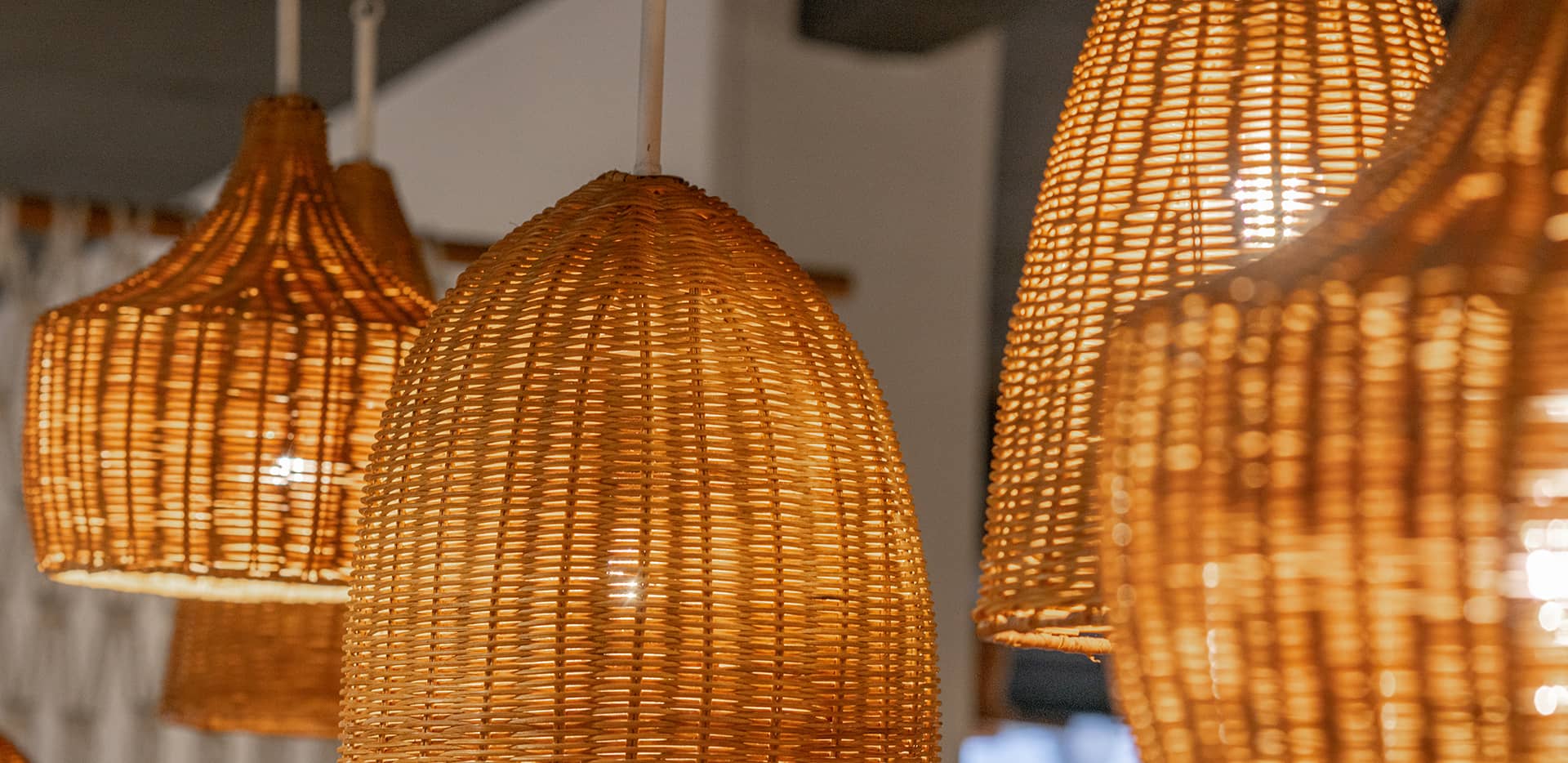 Verschiedene geflochtene Lampenschirme mit warmem Licht.