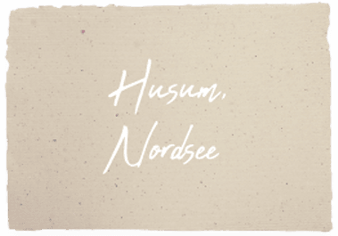 Schreibschrift Text auf Papierausschnitt mit dem Schriftzug „Husum, Nordsee“